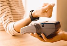 Kobieta przykładająca smartwatcha do terminala płatniczego