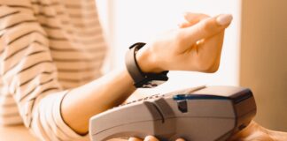 Kobieta przykładająca smartwatcha do terminala płatniczego